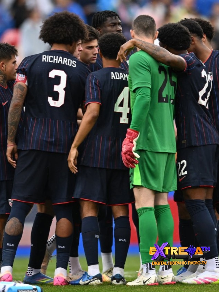 Jugadores del USMNT, incluyendo a Chris Richards (#3) y Tyler Adams (#4), reunidos en un cónclave en el campo.