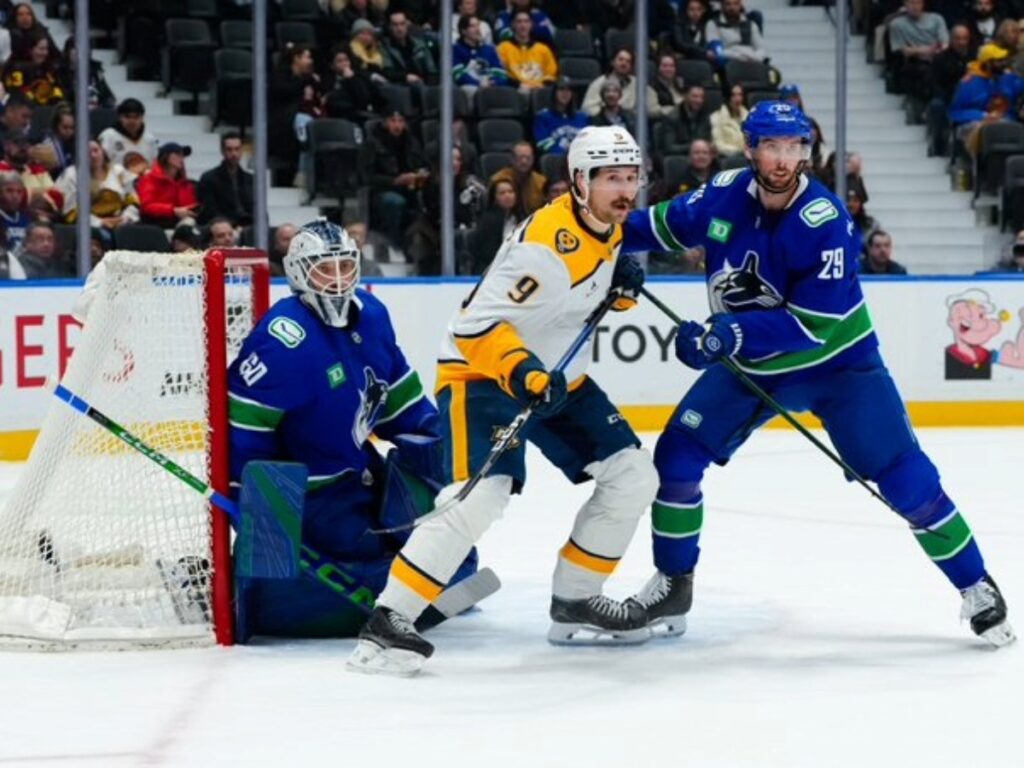 Jugador de los Nashville Predators presiona frente al arco de Nikita Tolopilo de los Vancouver Canucks en Rogers Arena durante la NHL 2026