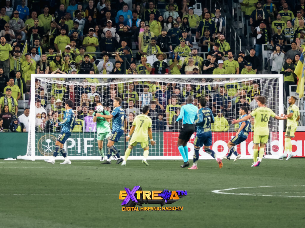Rodolfo Cota del Club America atrapa el balón bajo presión de Nashville SC en el GEODIS Park durante la Concacaf Champions Cup 2026 con Espinoza visible