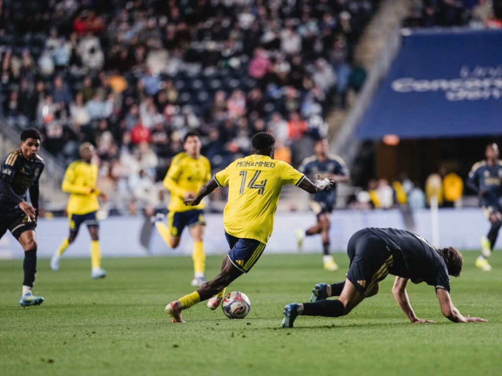 Mohammed de Nashville SC rematando ante la caída de un defensor rival