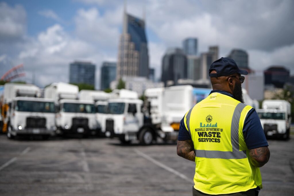 Empleado de Waste Services observa la nueva flotilla de camiones de basura en Nashville