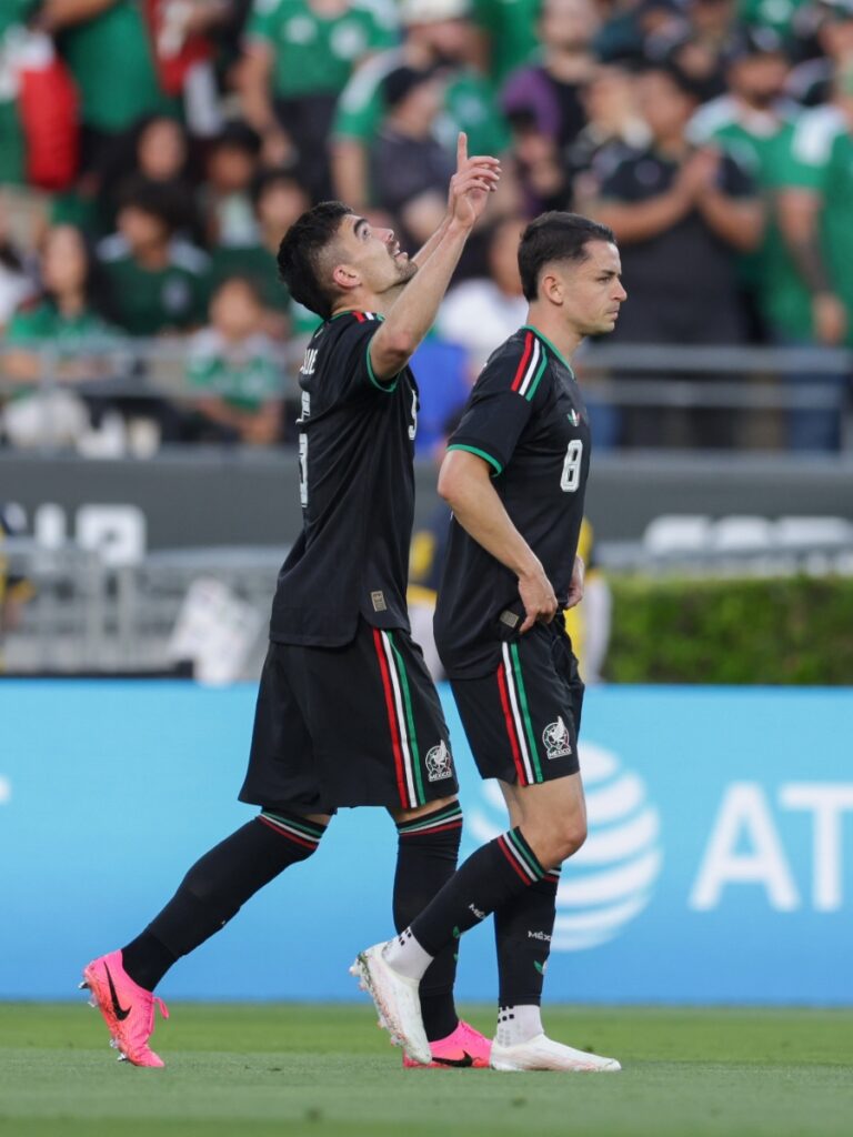Jugadores de México señalando al cielo tras la victoria ante Australia