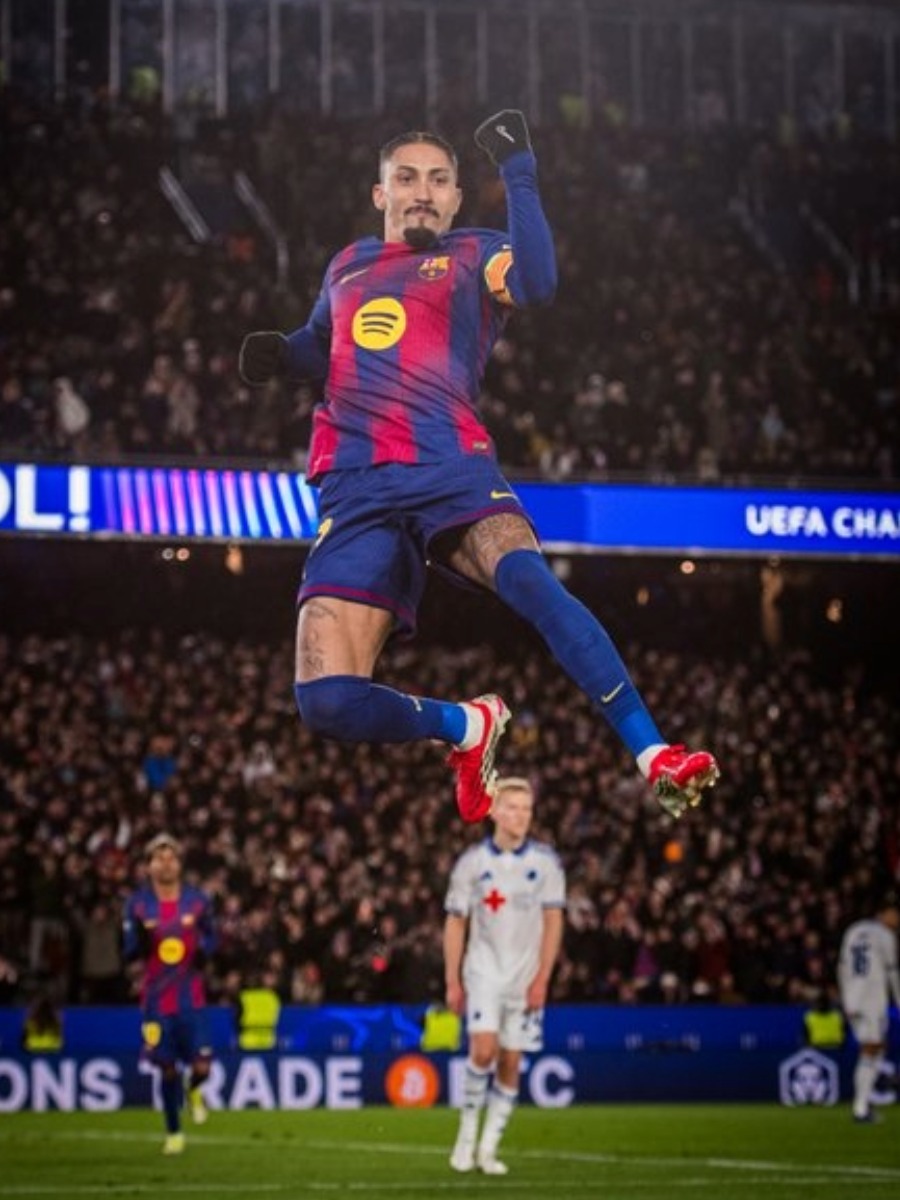 Raphinha del FC Barcelona salta con el puño en alto celebrando un gol en el Estadio Olímpico de Montjuïc.