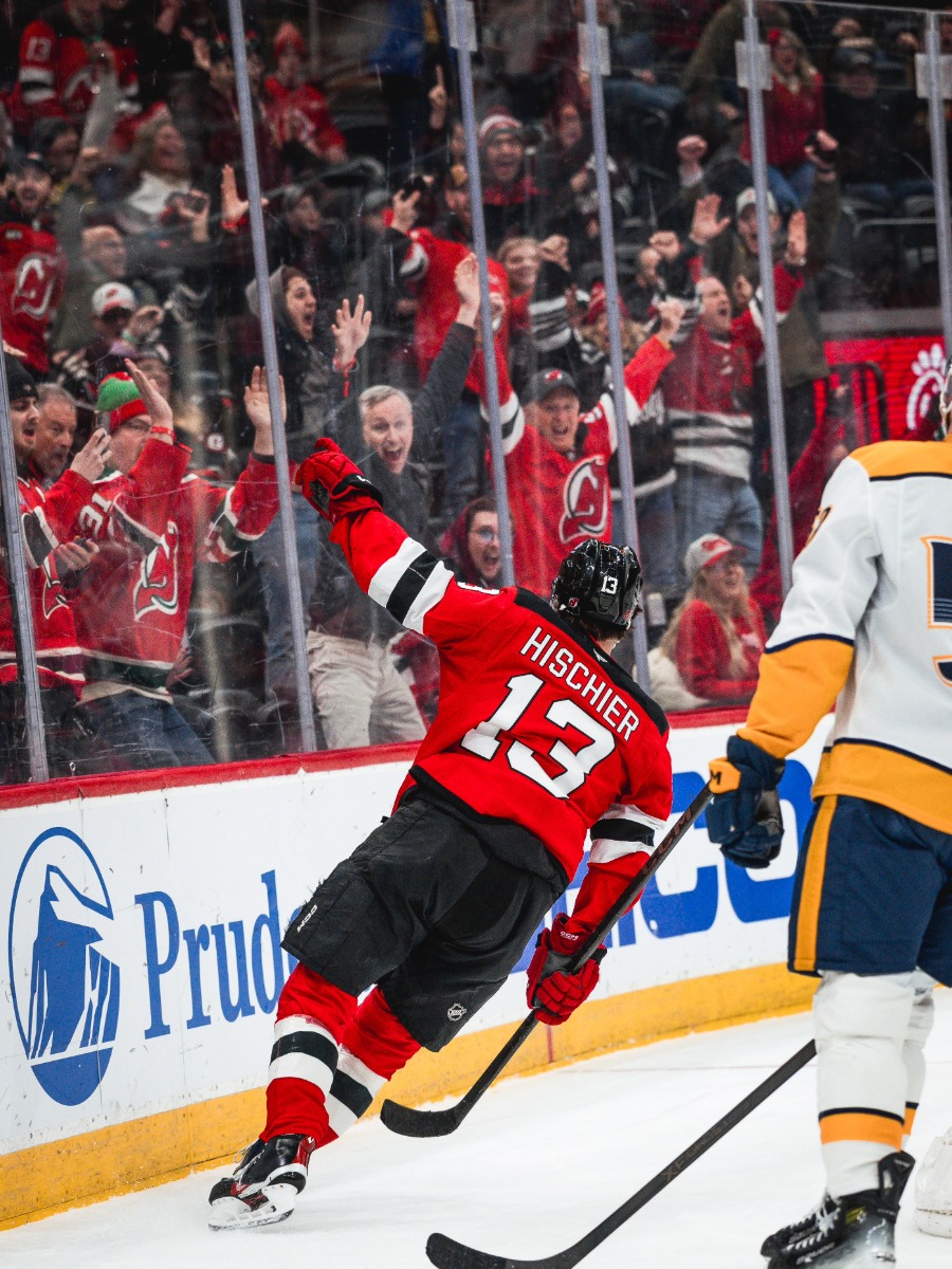 El capitán Nico Hischier (#13) celebra eufórico frente a la afición de los Devils en Newark.