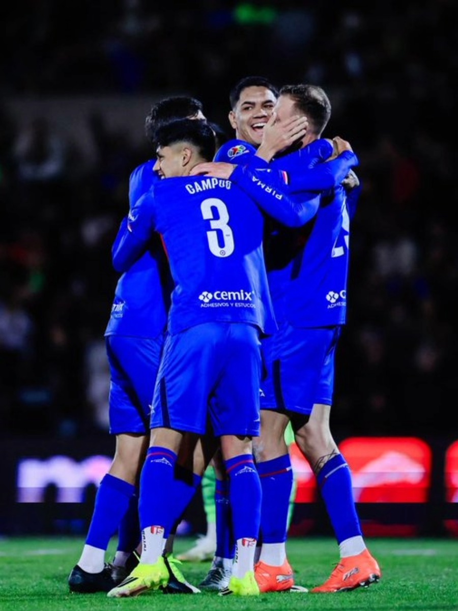 Jugadores de Cruz Azul se abrazan celebrando un gol decisivo ante la presión del cierre del partido.