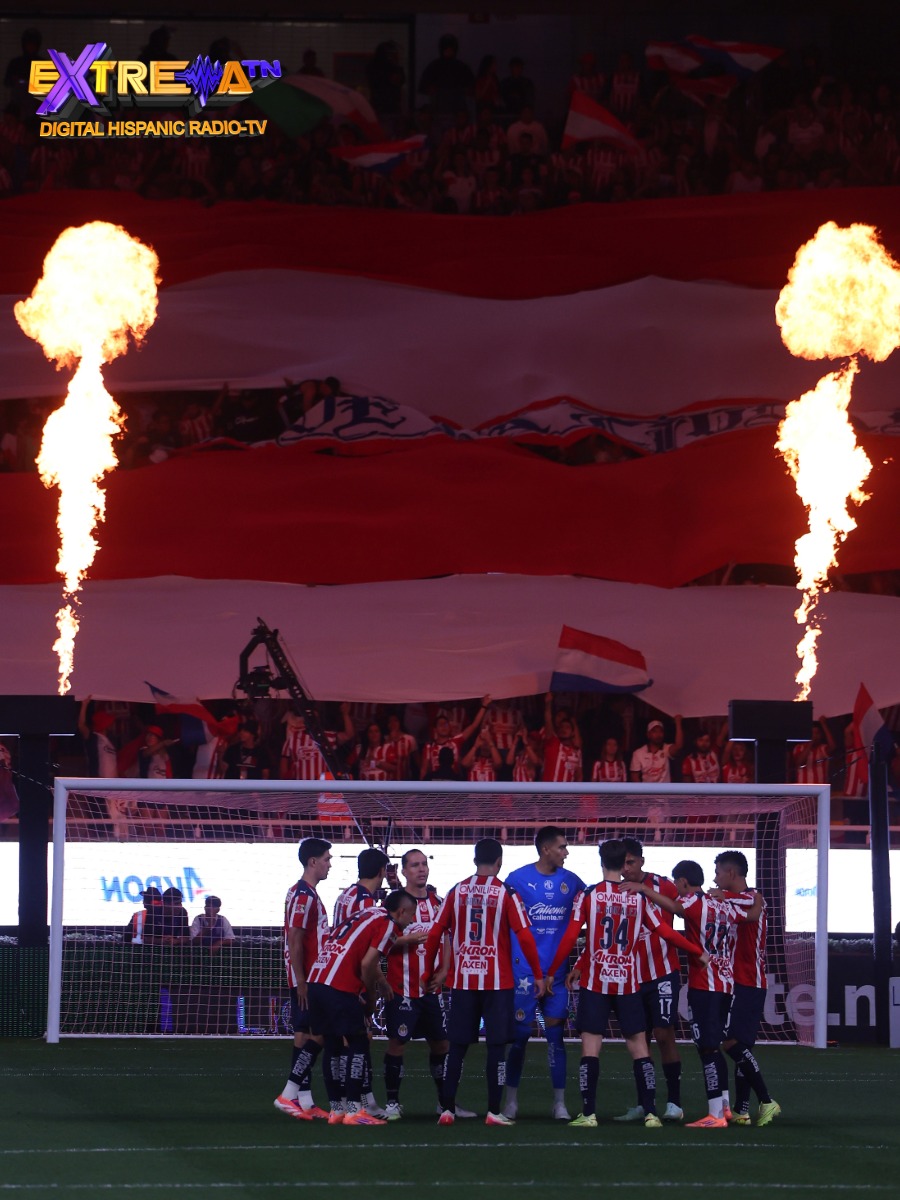 Jugadores de Chivas reunidos en el Estadio Akron con la afición rojiblanca alentando desde la tribuna.
