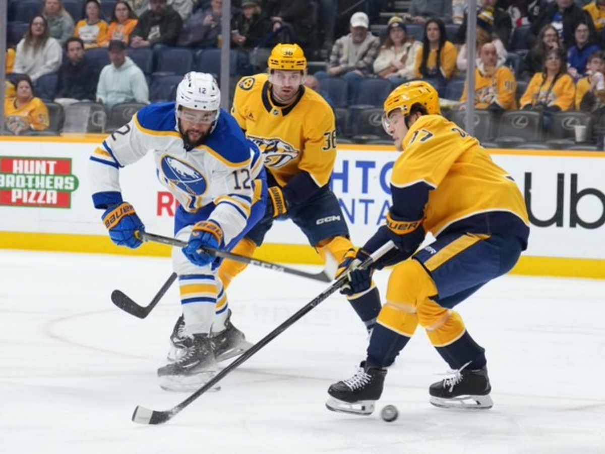 Acción intensa Sabres presiona a Predators en puck durante derrota 3-5 en Bridgestone Arena enero 2026