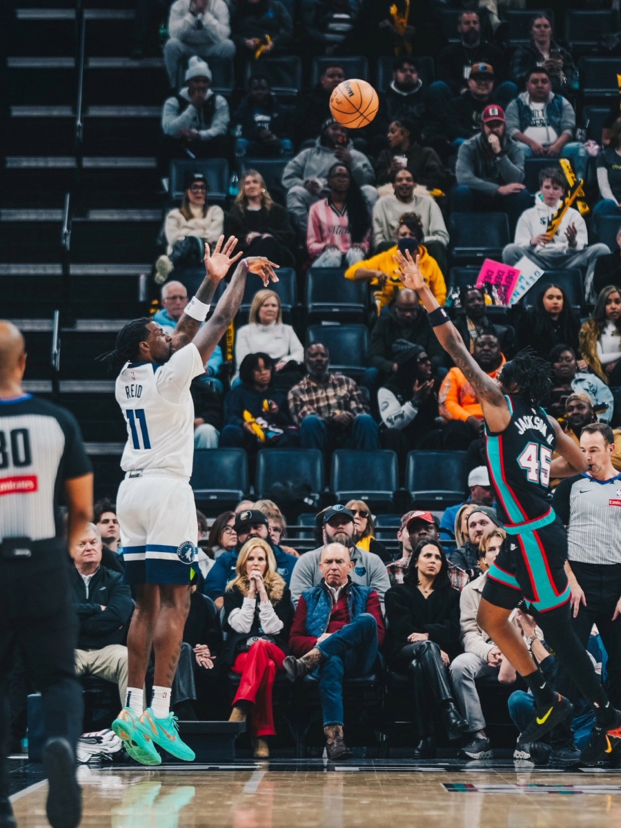 Naz Reid (#11) de los Minnesota Timberwolves realiza un tiro de tres puntos durante el partido contra Memphis Grizzlies en 2026.