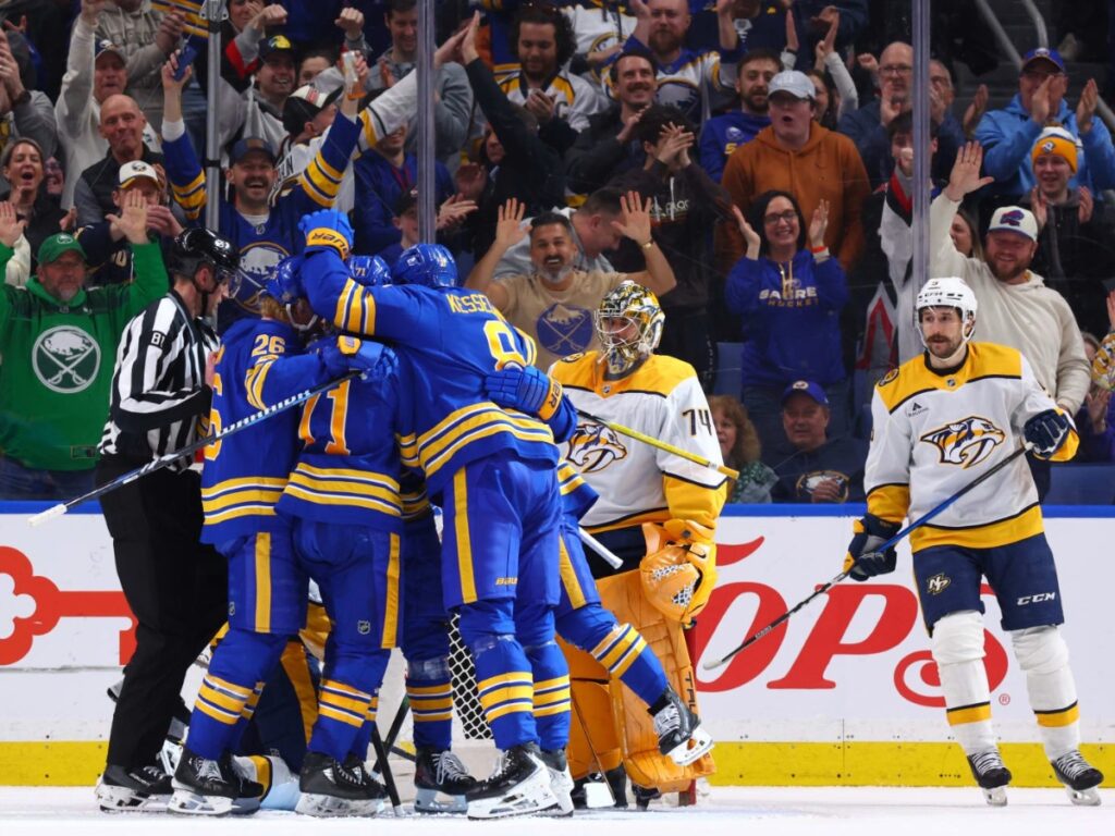 Jugadores de los Buffalo Sabres celebran un gol ante los Nashville Predators en el KeyBank Center durante la temporada NHL 2026 con Juuse Saros al fondo