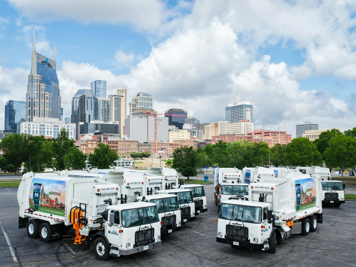 Nueva flotilla de camiones de basura y reciclaje presentada por Nashville con el skyline de la ciudad al fondo