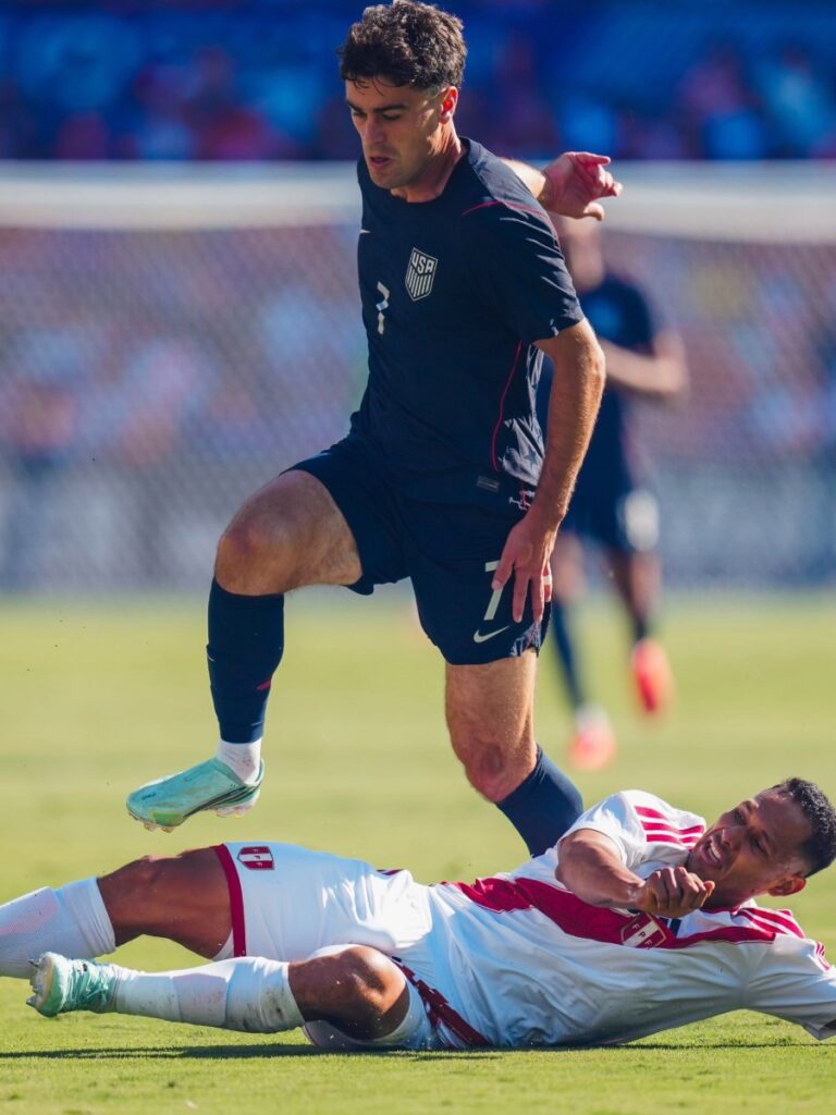 Giovanni Reyna elude la barrida del defensor peruano en el césped del Inter&Co Stadium