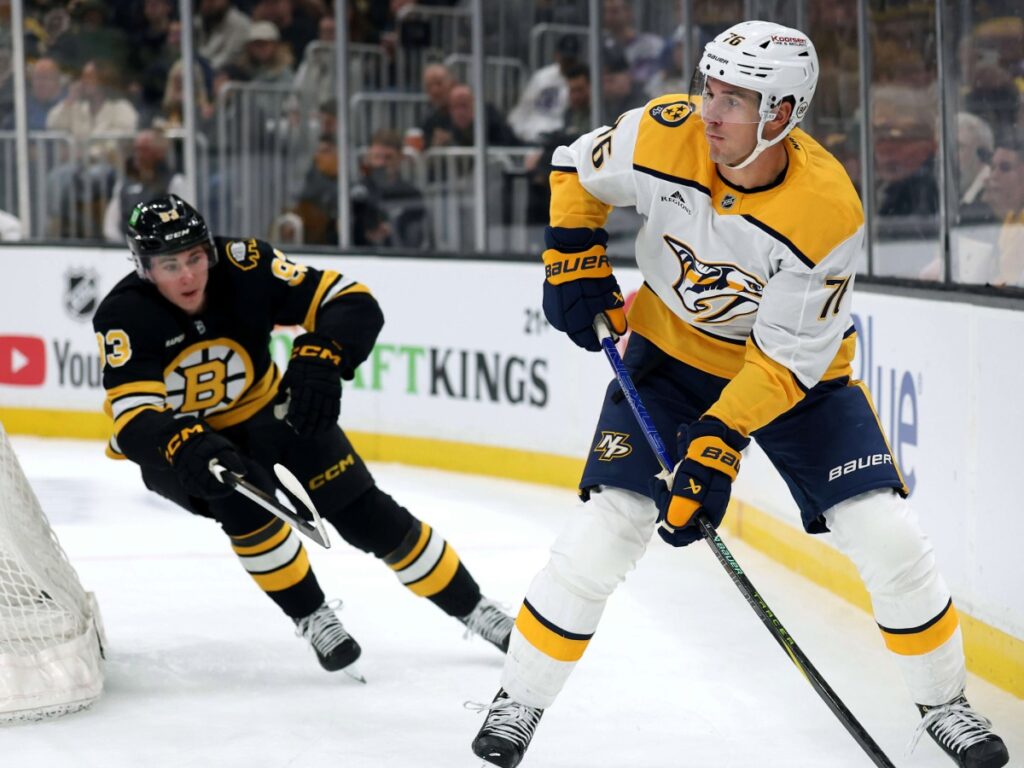 Brady Skjei resguarda su área ante la presión del delantero de Boston Bruins