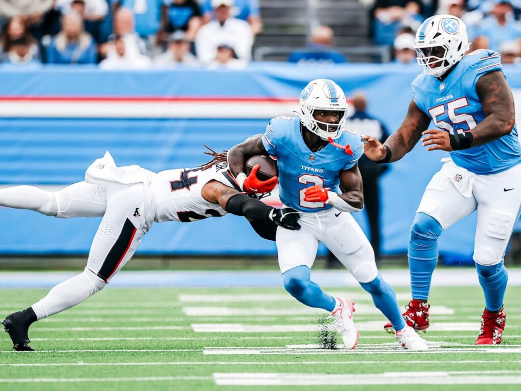Calvin Ridley es frenado por la defensiva rival en el transcurso de la caída de Tennessee Titans