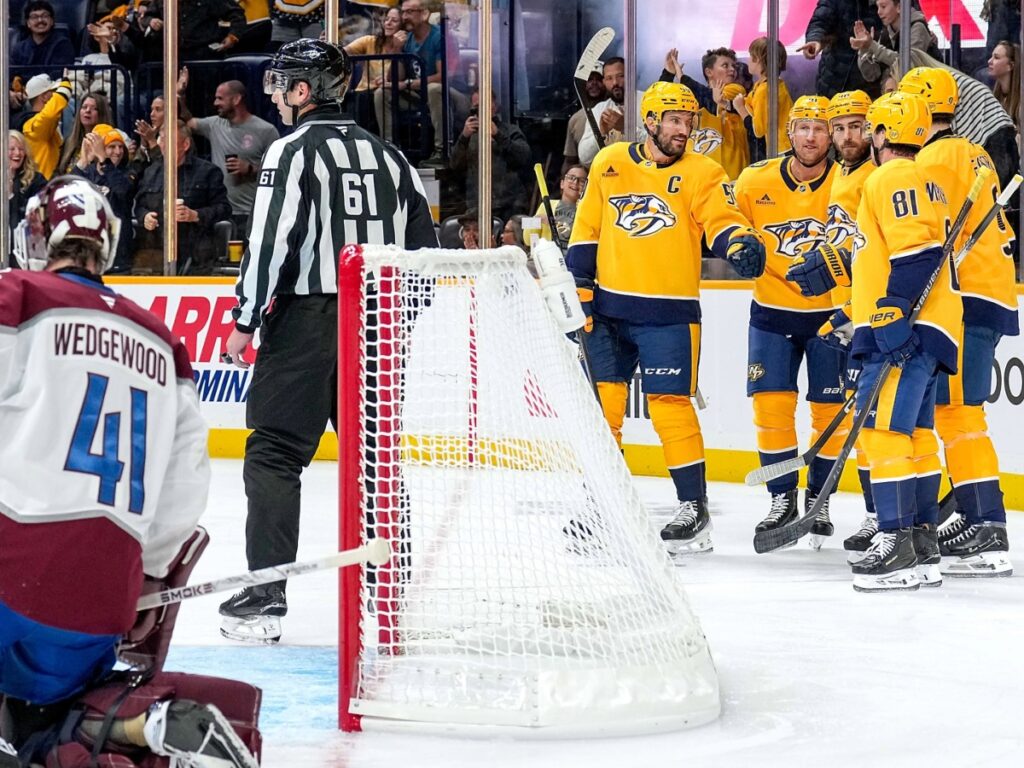 Jugadores de Nashville Predators celebran ante la portería en la goleada de Nashville Predators ante Avalanche