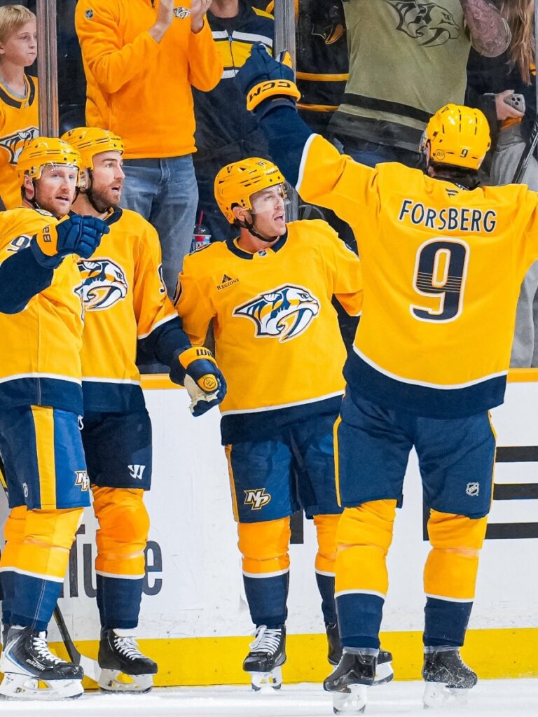 Filip Forsberg y Steven Stamkos celebran con los brazos en alto junto al acrílico