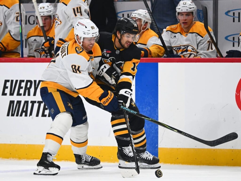 Jonathan Marchessault forcejea protegiendo el puck en la valla perimetral