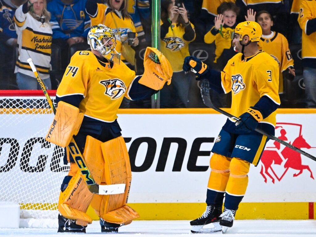 Juuse Saros y Jayden Struble chocan los guantes durante el triunfo de Nashville Predators ante Blues