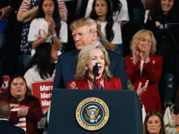 Marsha Blackburn habla ante los asistentes con Donald Trump detrás durante el evento en Clarksville, Tennessee.