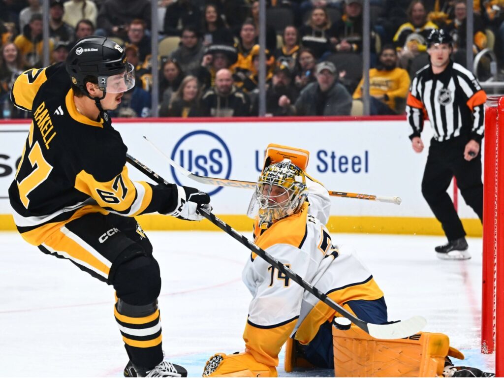 Rickard Rakell empuja el disco ante la estirada de Juuse Saros en la caída de Nashville Predators ante Penguins
