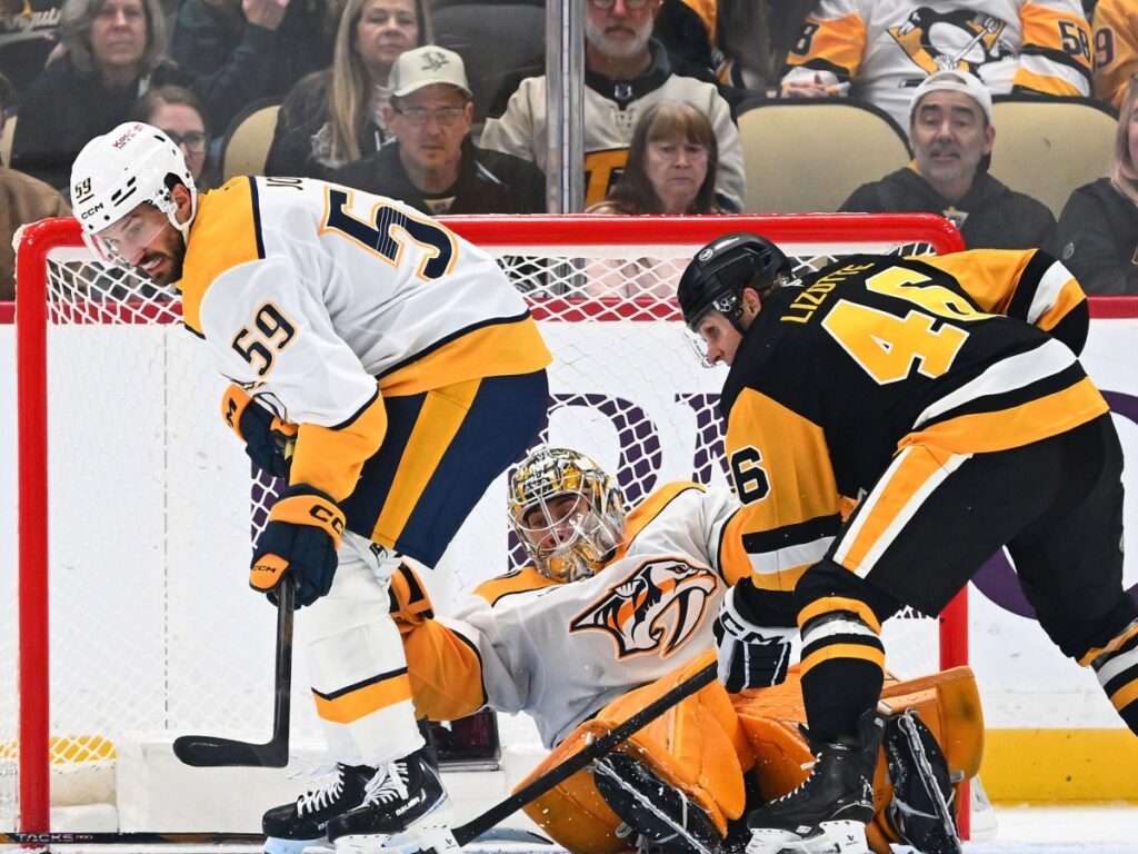 Roman Josi y Juuse Saros protegen su portería durante la caída de Nashville Predators ante Penguins