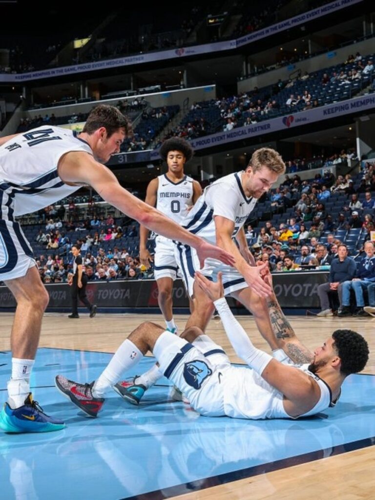 Quinten Post y Cam Spencer ayudan a levantar a Ty Jerome de la duela